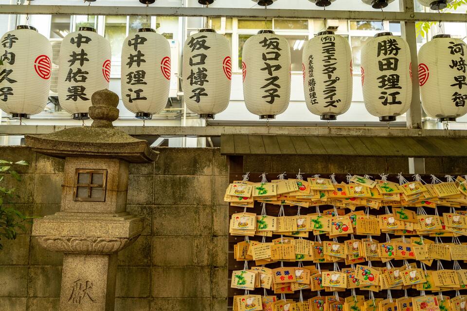 Traditional Japanese lanterns and wooden plaques with inscriptions.