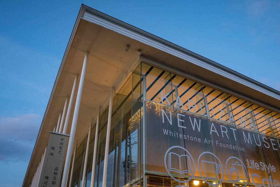 Exterior do Novo Museu de Arte com um céu claro ao fundo.