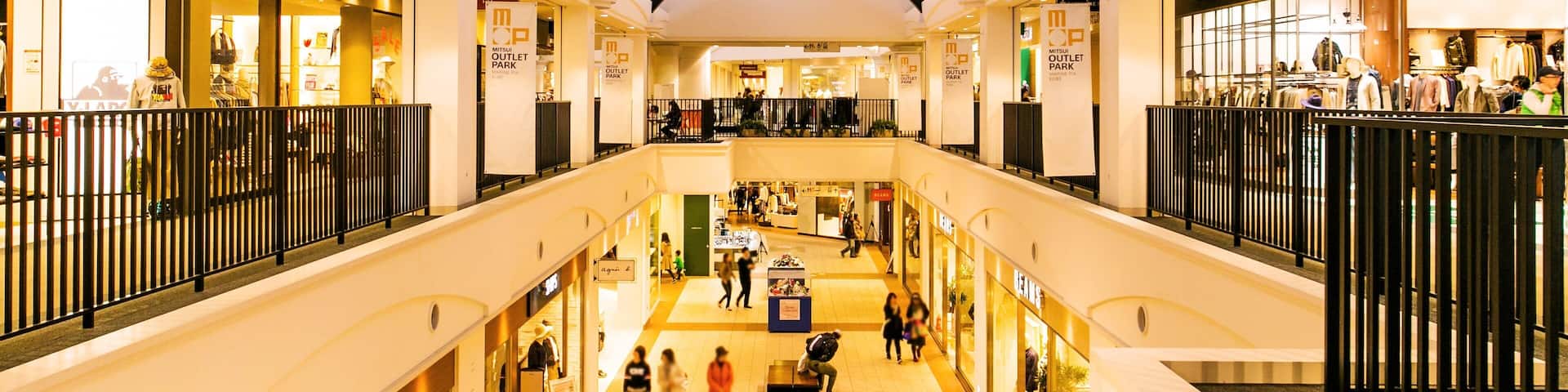 A multi-level shopping mall with various stores and a central open space.