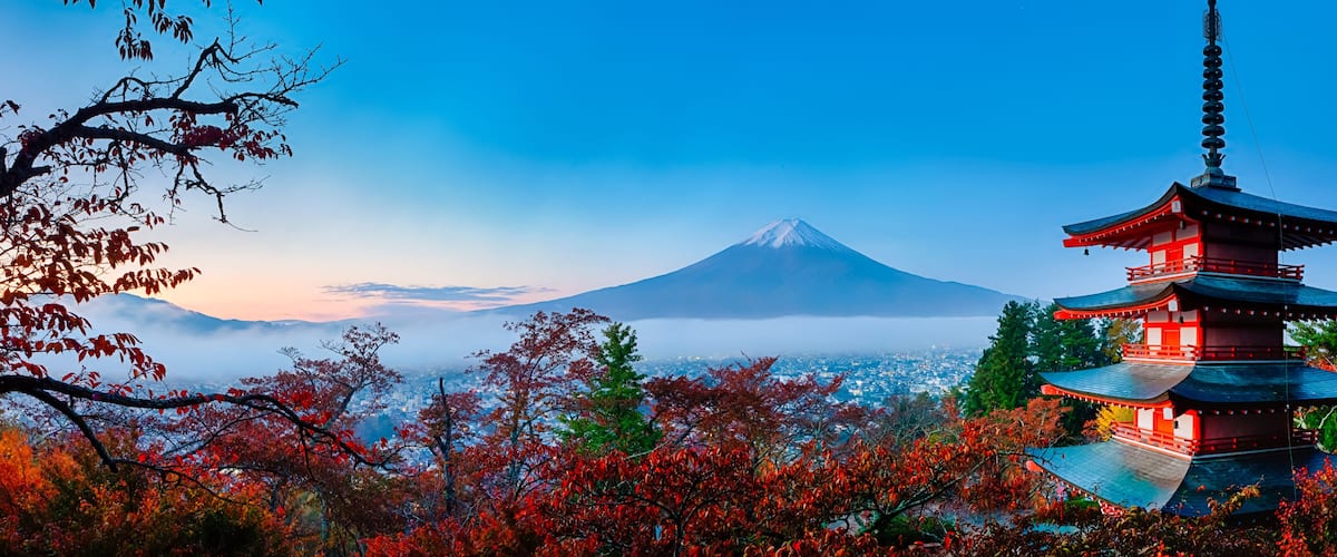 A pagoda, autumn foliage, and a mountain.