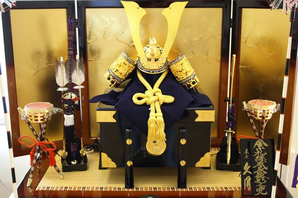 A traditional Japanese shrine with golden decorations, a central altar, and ritual items.