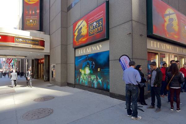 Broadway Theatre som viser skiltning og en by såvel som en lille gruppe mennesker