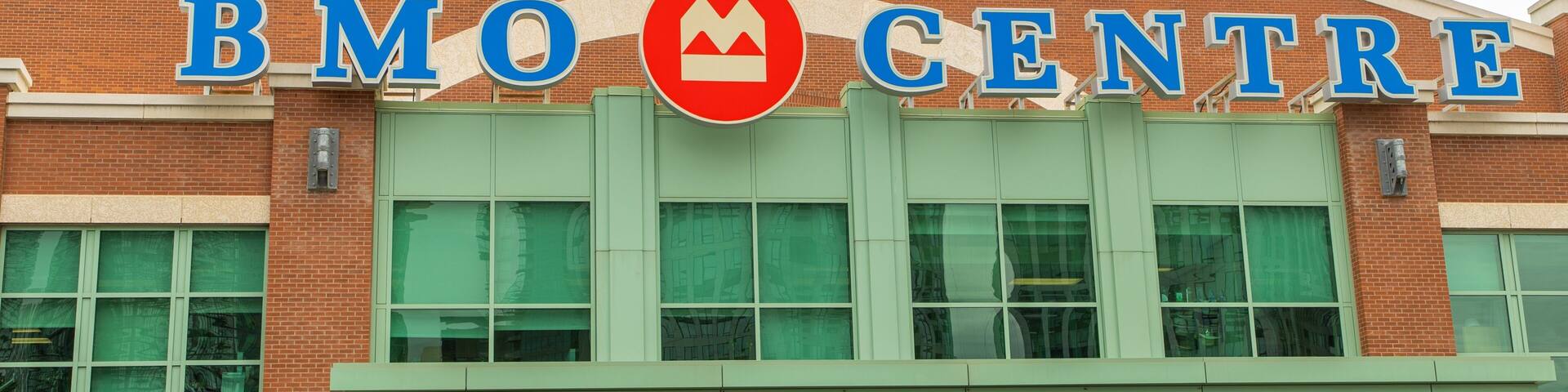 A building with a sign reading "BMO CENTRE" and a red circular logo with a mountain design.