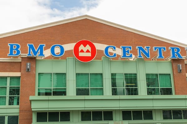 Un bâtiment sur lequel on peut lire l’inscription « BMO CENTRE », et qui arbore un logo circulaire rouge représentant une montagne.