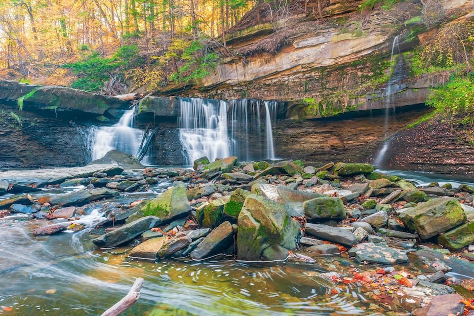 A waterfall cascading over rocks in a forested area.