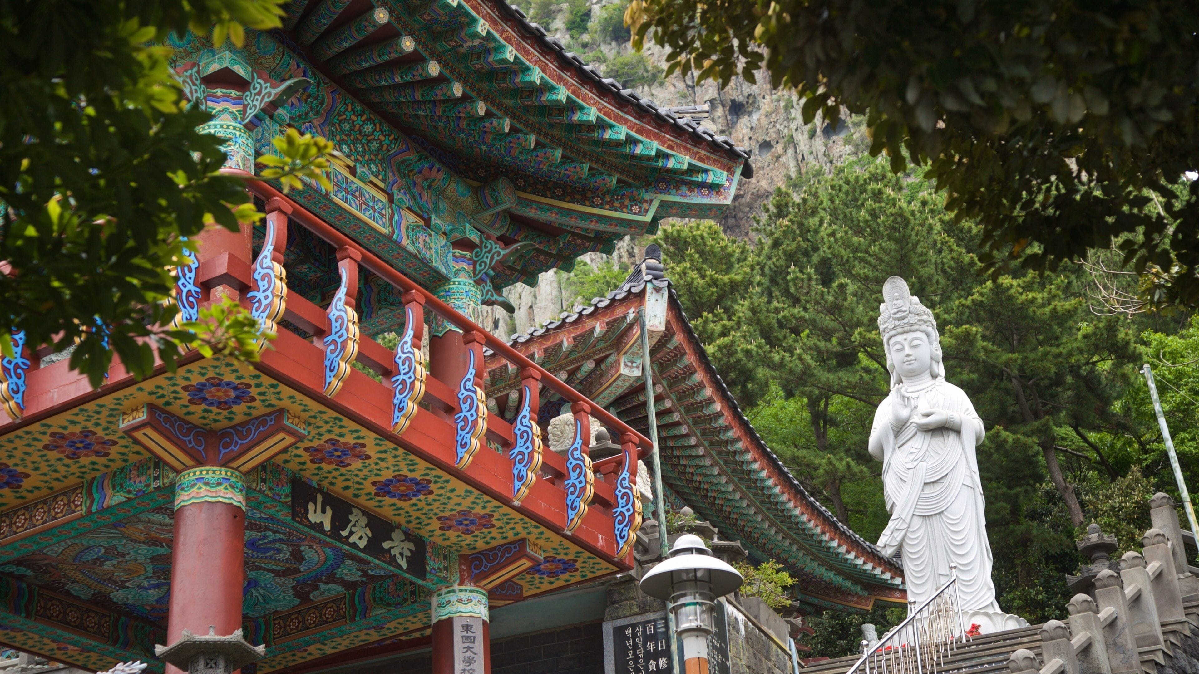 Sanbangsan Mountain showing a statue or sculpture and heritage elements as well as a small group of people