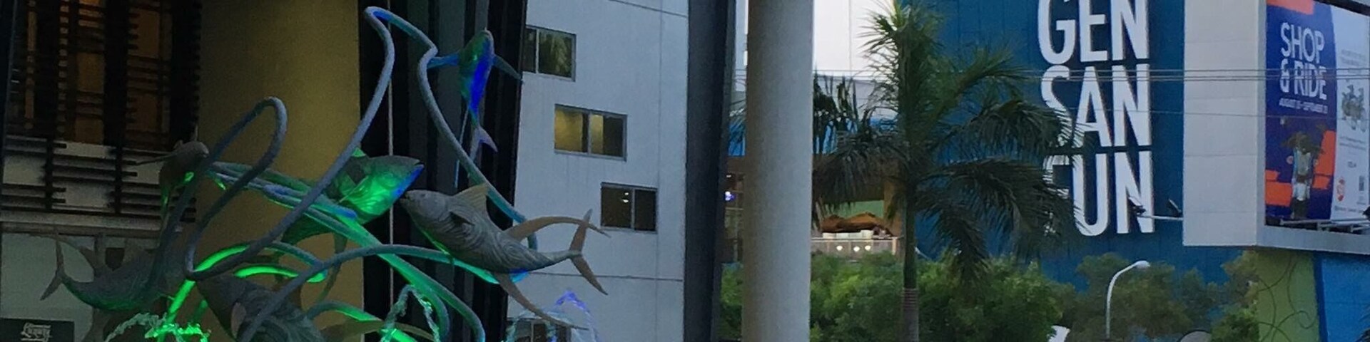 A modern building with a curved roof and a sign that reads "GEN SAN SUN".