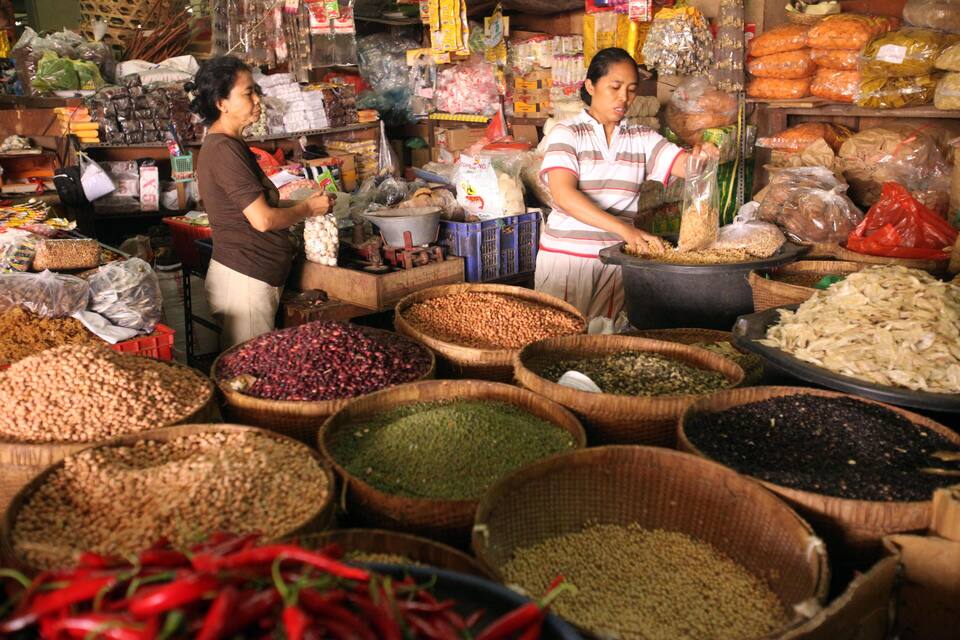 A market with various grains and spices displayed in large baskets.
