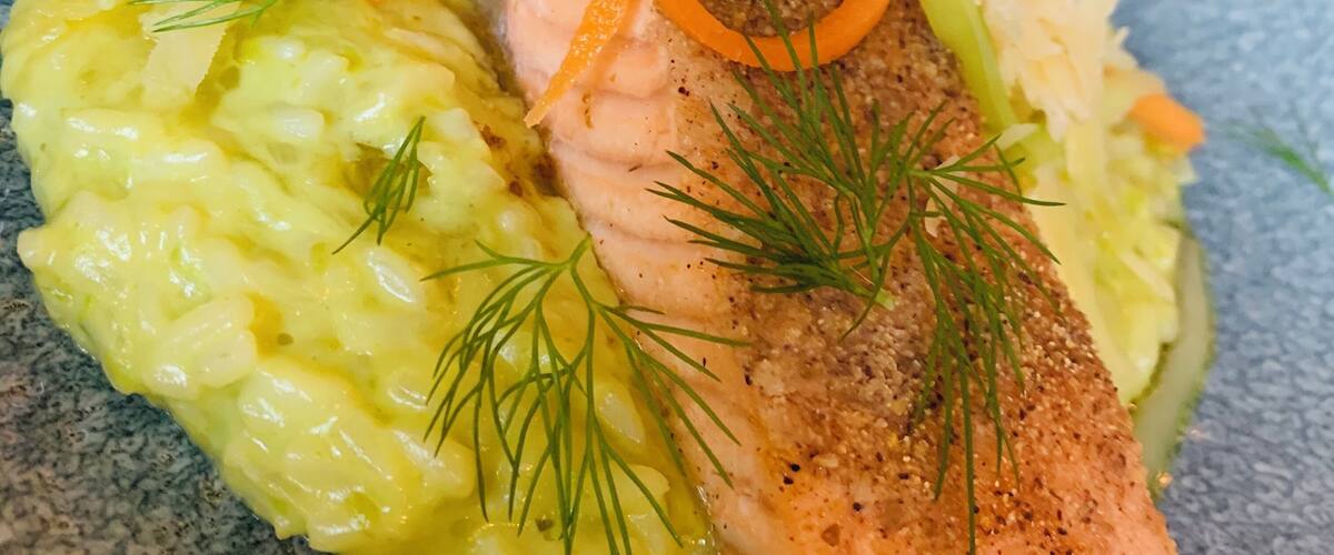 A plate of food with salmon, mashed potatoes, and a salad.