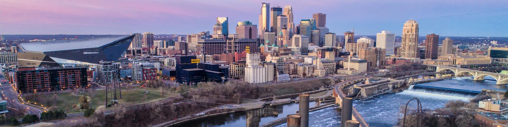 A city skyline with a river, bridges, and industrial structures.