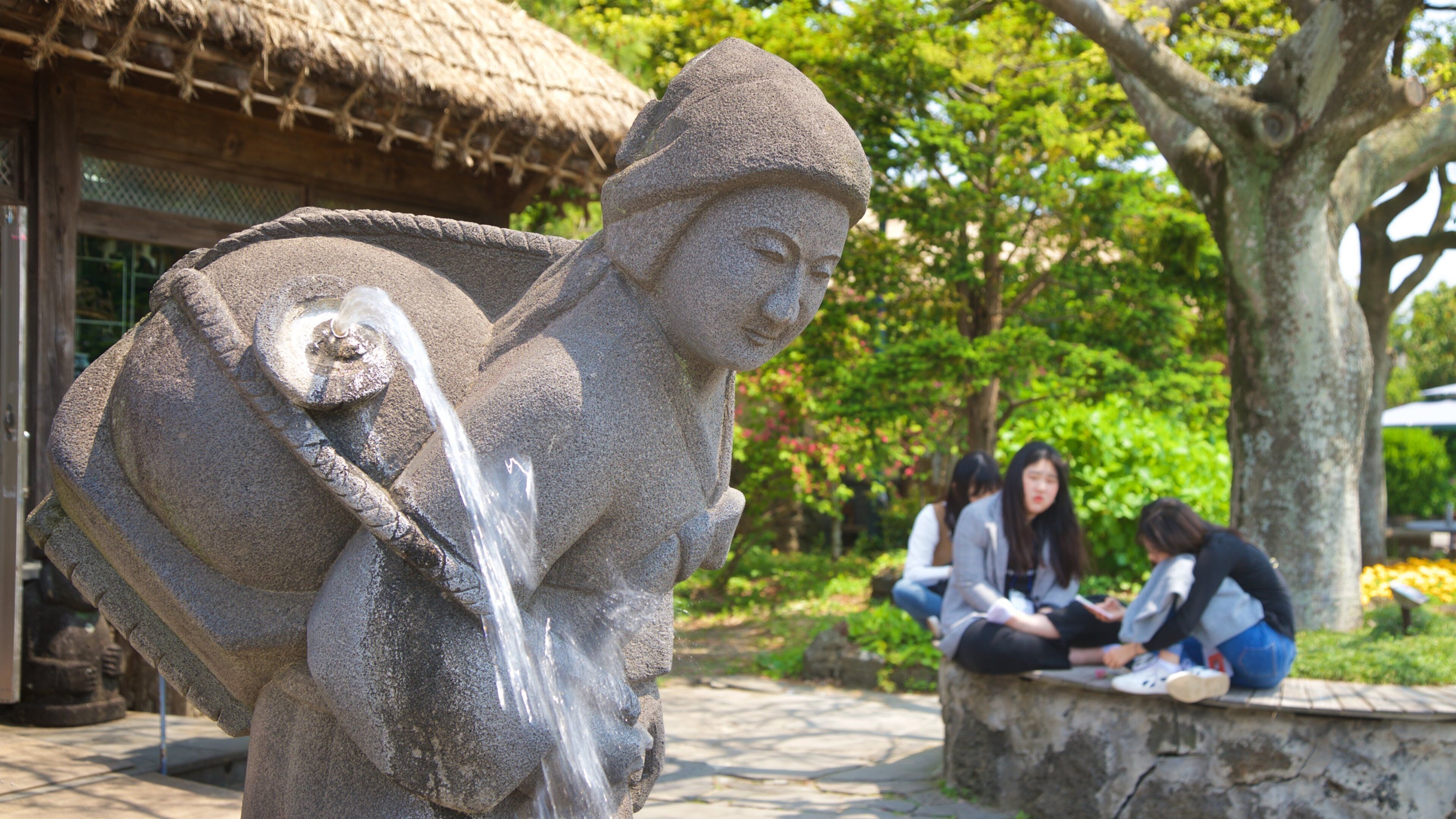 Jeju Folk Village Museum showing a statue or sculpture and a fountain