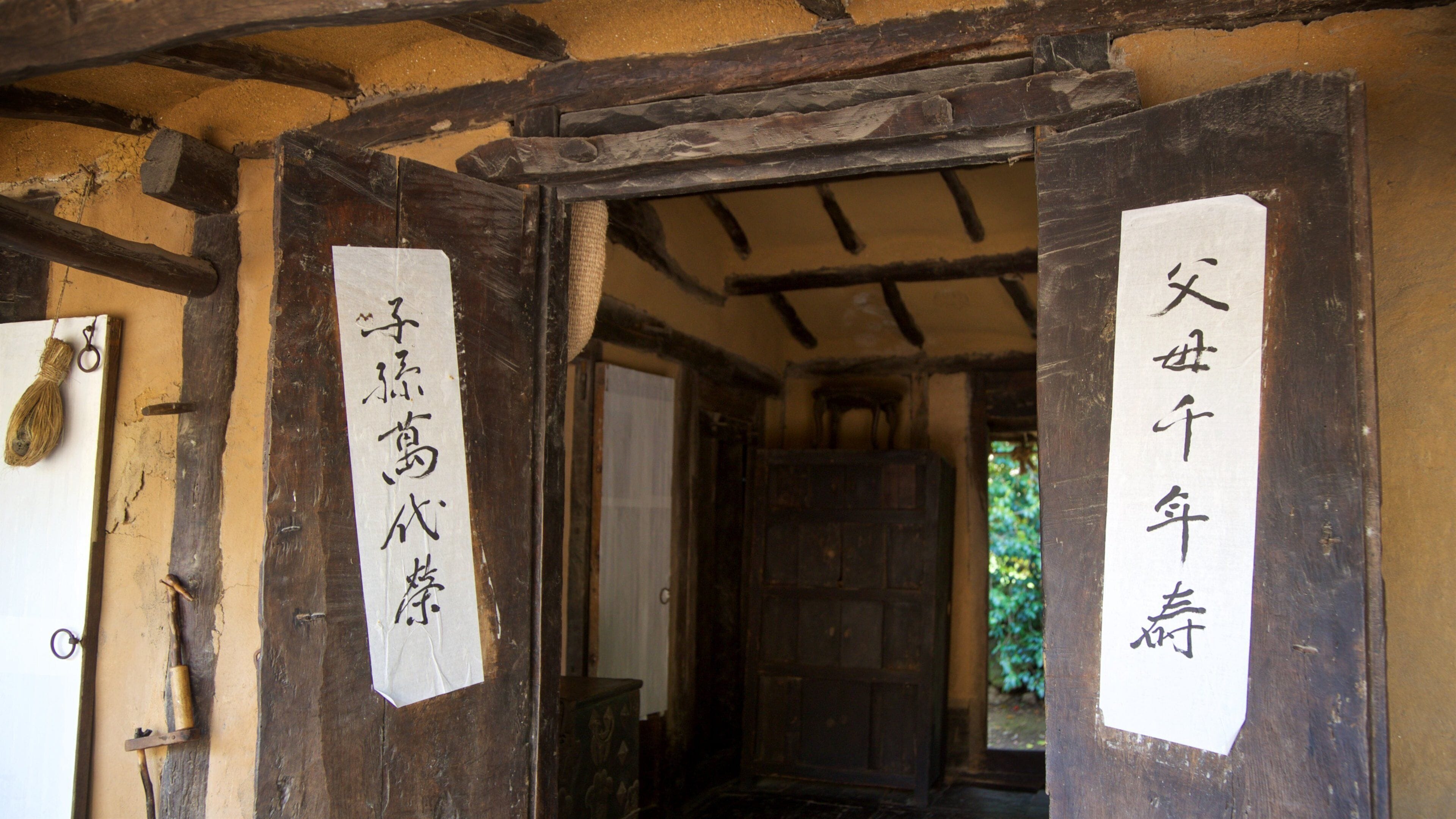 Jeju Folk Village Museum showing signage and a house
