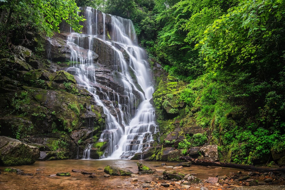 Ein mehrstufiger Wasserfall, umgeben von üppiger, grüner Vegetation.