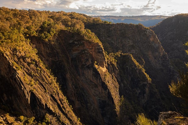 A canyon with steep cliffs and sparse vegetation.