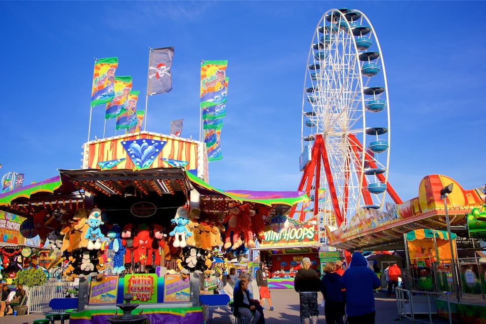 A vibrant amusement park with a Ferris wheel, a prize factory, and various rides and attractions.