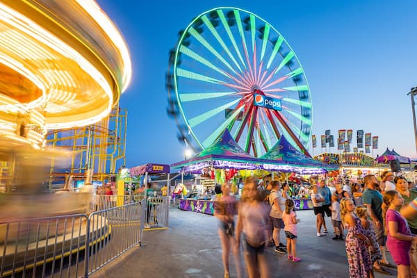 Jolly Roger at the Pier featuring night scenes and rides as well as a large group of people