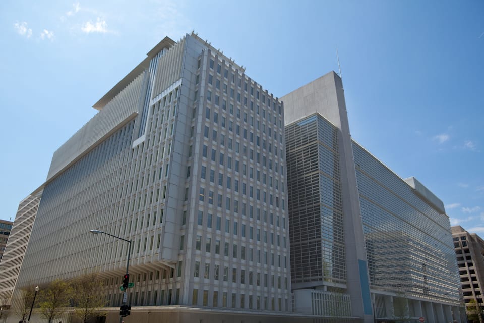 A modern skyscraper with a grid-like facade and a prominent spire.