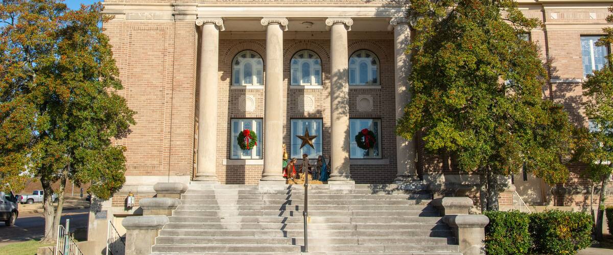 Greek-style temple front view of the Classical Revival style historic First United Methodist Church and community center on Izard Street in Forrest City, Arkansas, USA