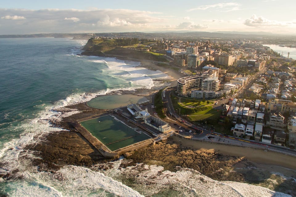 Una ciudad costera con un puerto, edificios y una playa.