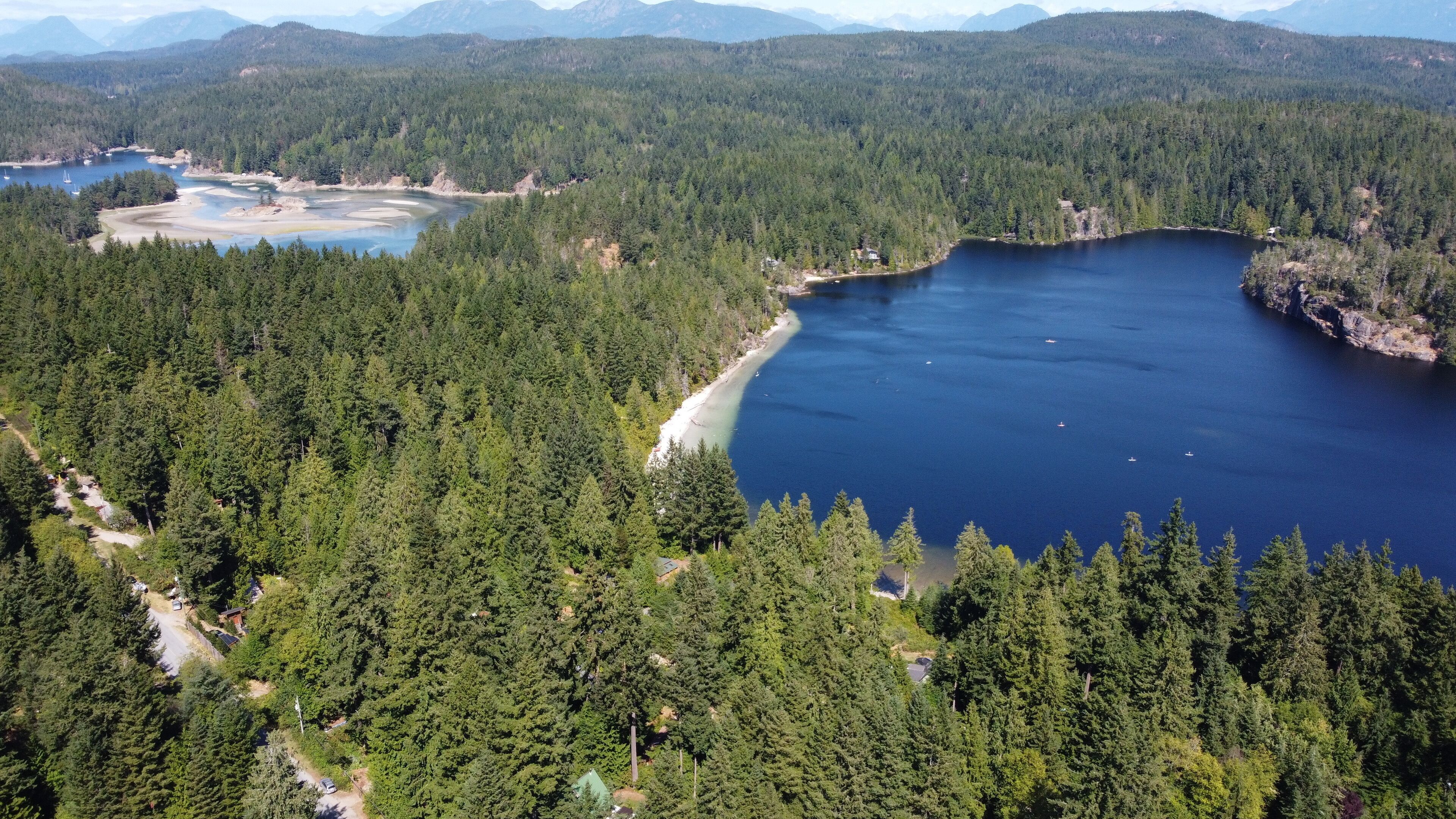 A lake surrounded by dense forest and mountains.