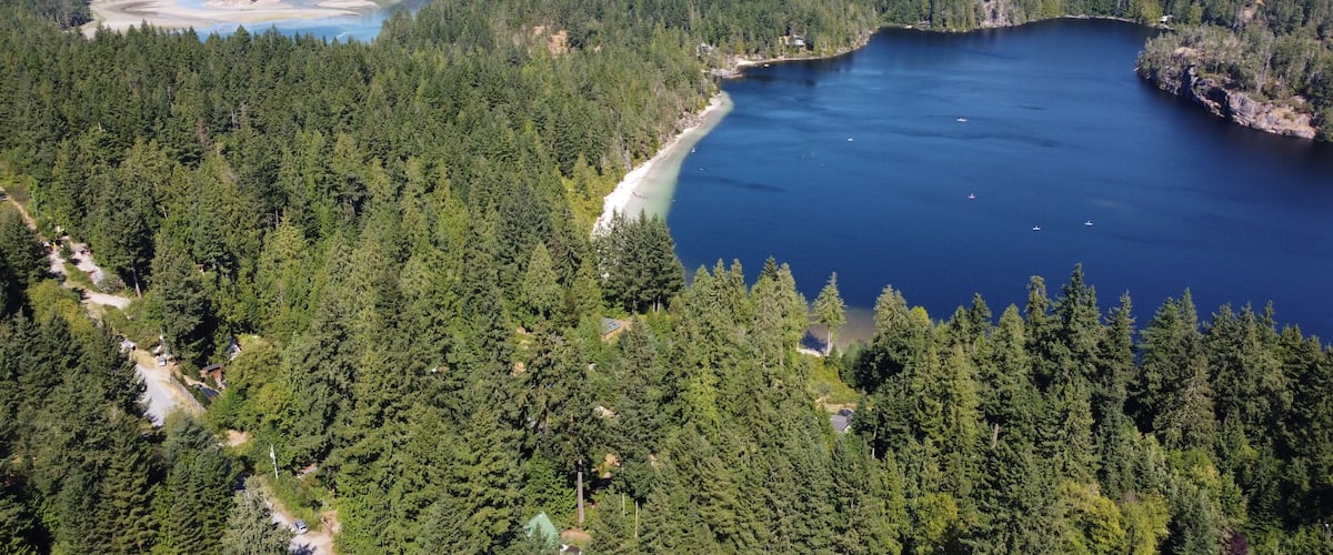 A lake surrounded by dense forest and mountains.