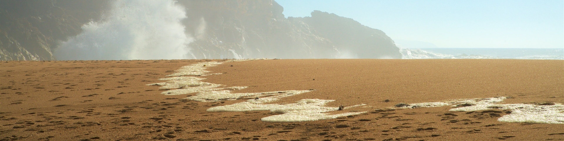 Norte Beach featuring rocky coastline, a beach and mist or fog