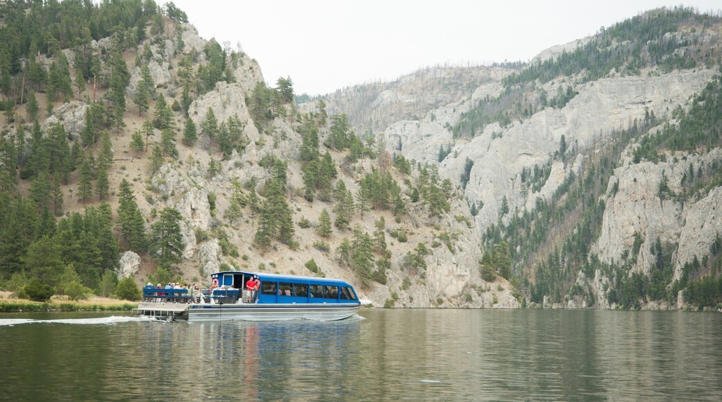 Montana mostrando paseos en lancha, montañas y un lago o abrevadero
