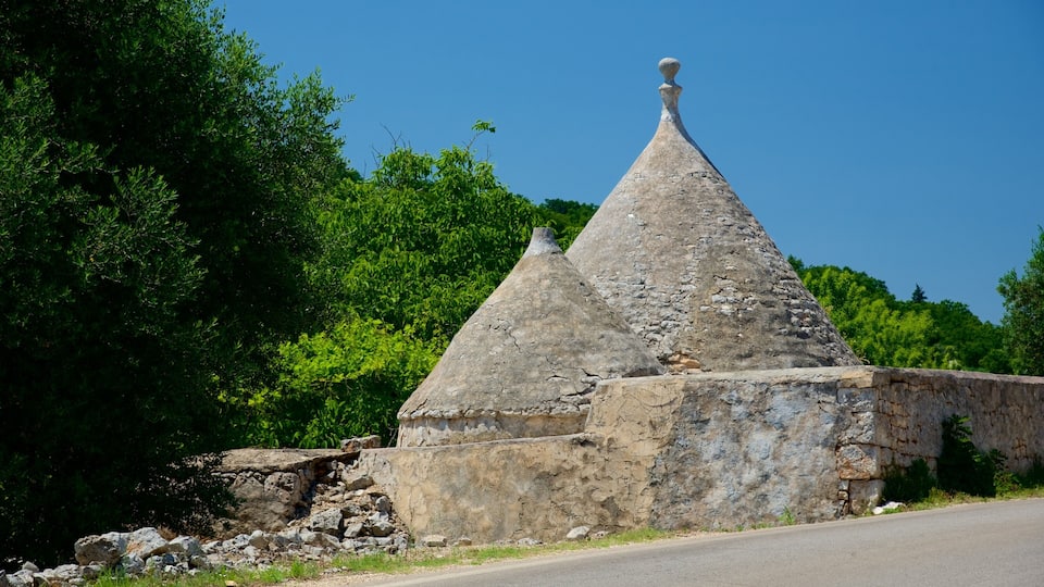 A stone building with conical roofs and a stone wall.