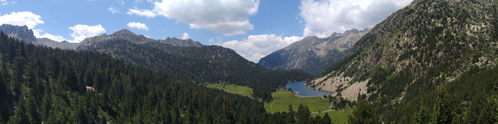 Landscape in the National Park of Aigüestortes and Lake San Mauricio. View of the Lake Llong and the valley. Pyrenees Mountains. Catalonia. Spain.
