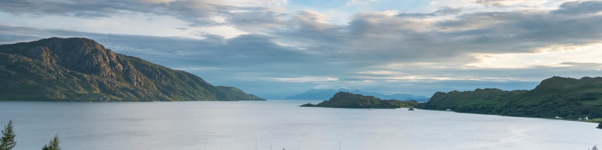 Big skies hang over Loch Nevis where a small ship is docked near Inverie, Scotland; Inverie, Scotland