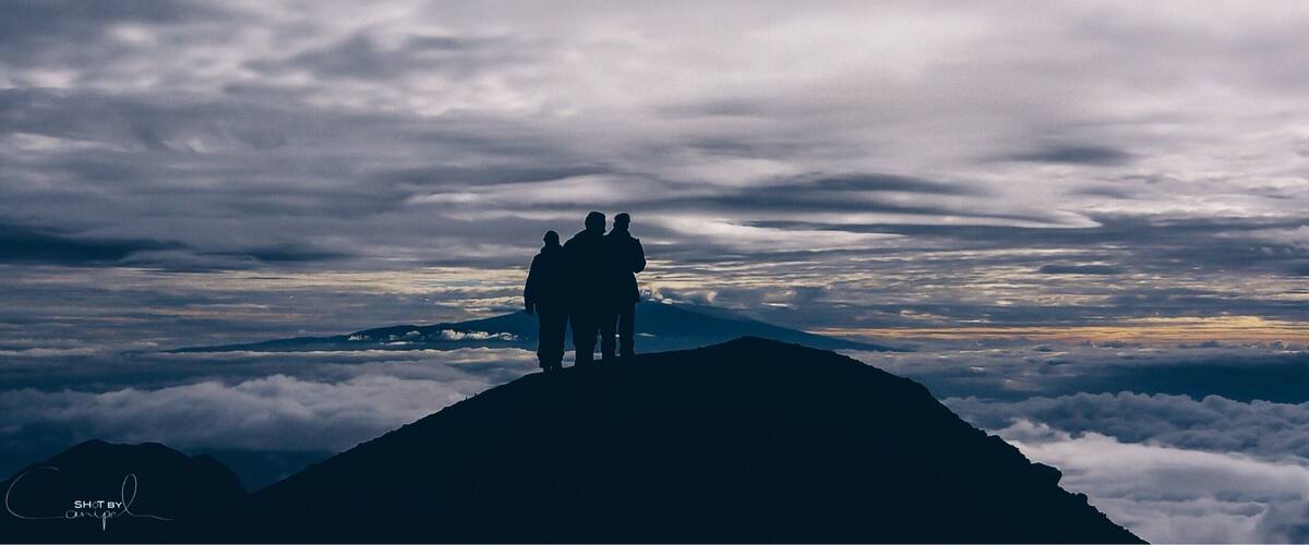 Trekking to 4565m high summit of Mount Meru in Tanzania. A hike through the beautiful national park of Arusha and meeting the african wildlife. One makes this trip unforgettable, a constant view on the wonderful Kilimanjaro. This early morning photo is taking just below the top of Mount Meru between two layers of clouds and only the peak of Kilimanjora on the Horizon. #nationalpark #africa #summit #meru #wilderness #travel #hiking #mountains