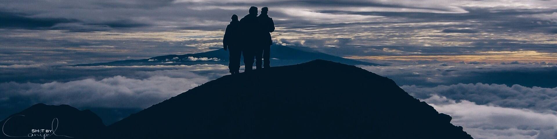 Trekking to 4565m high summit of Mount Meru in Tanzania. A hike through the beautiful national park of Arusha and meeting the african wildlife. One makes this trip unforgettable, a constant view on the wonderful Kilimanjaro. This early morning photo is taking just below the top of Mount Meru between two layers of clouds and only the peak of Kilimanjora on the Horizon. #nationalpark #africa #summit #meru #wilderness #travel #hiking #mountains