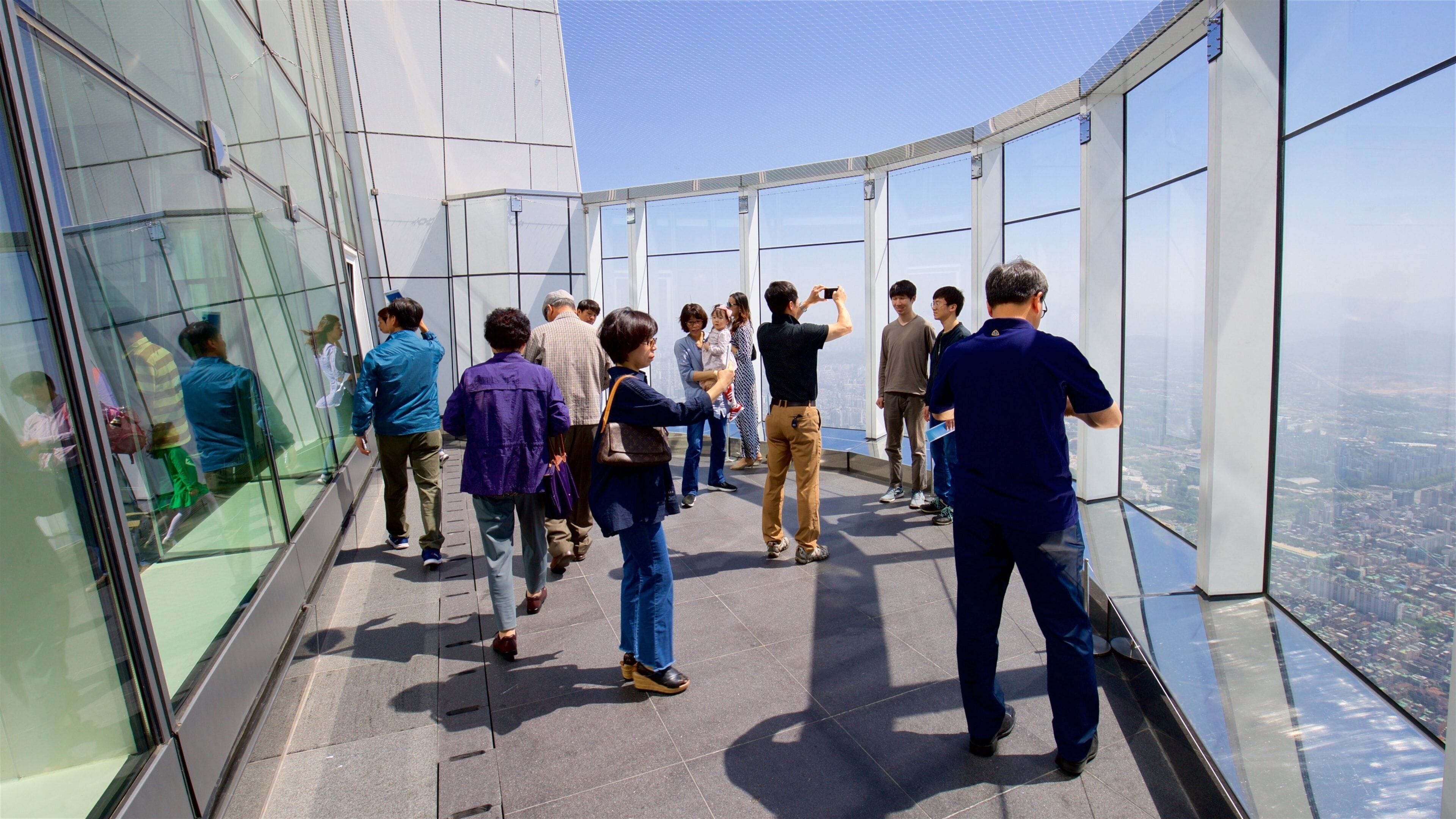 Lotte World Tower caracterizando paisagens assim como um pequeno grupo de pessoas