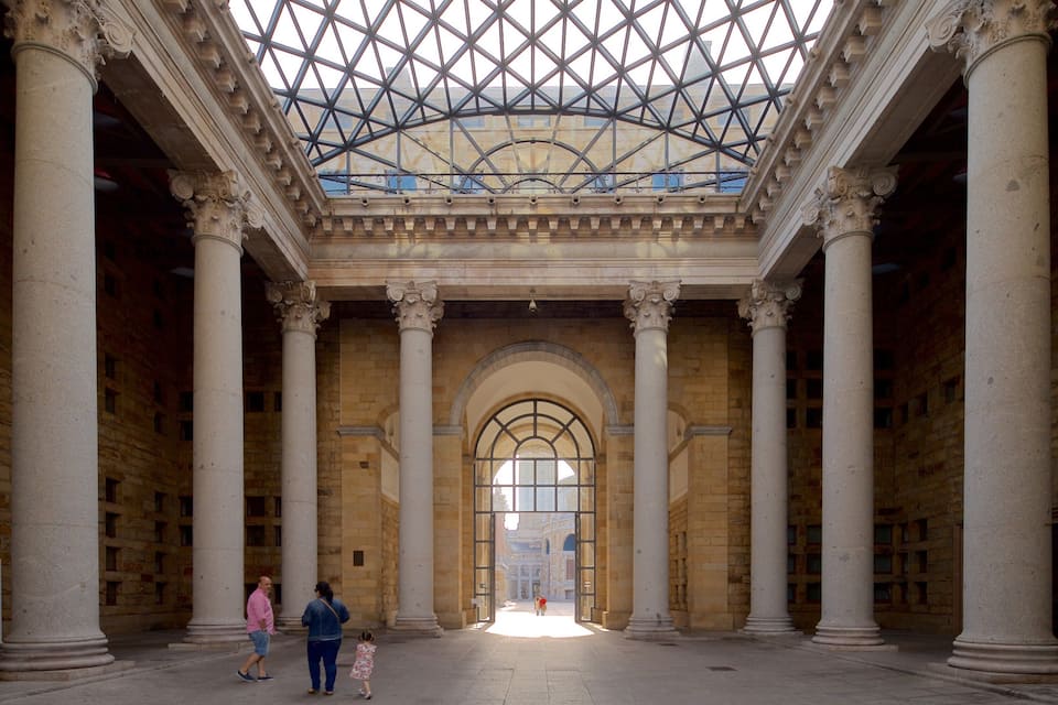 A grand hall with large columns, a glass ceiling, and an arched doorway.