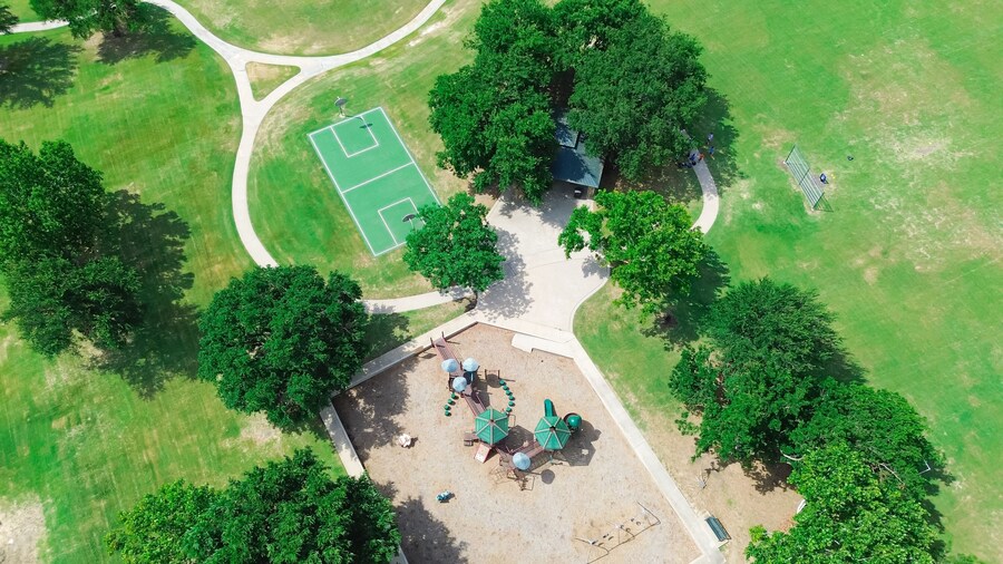 Baseball softball field with backstop netting, basketball courts, children playground equipment structure in upscale residential area West of Plano, Texas, swing, slide, woodchips ground, aerial