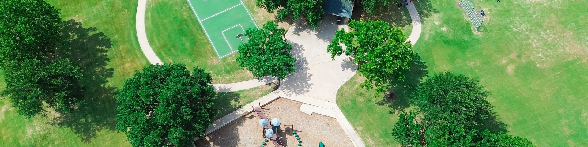 Baseball softball field with backstop netting, basketball courts, children playground equipment structure in upscale residential area West of Plano, Texas, swing, slide, woodchips ground, aerial