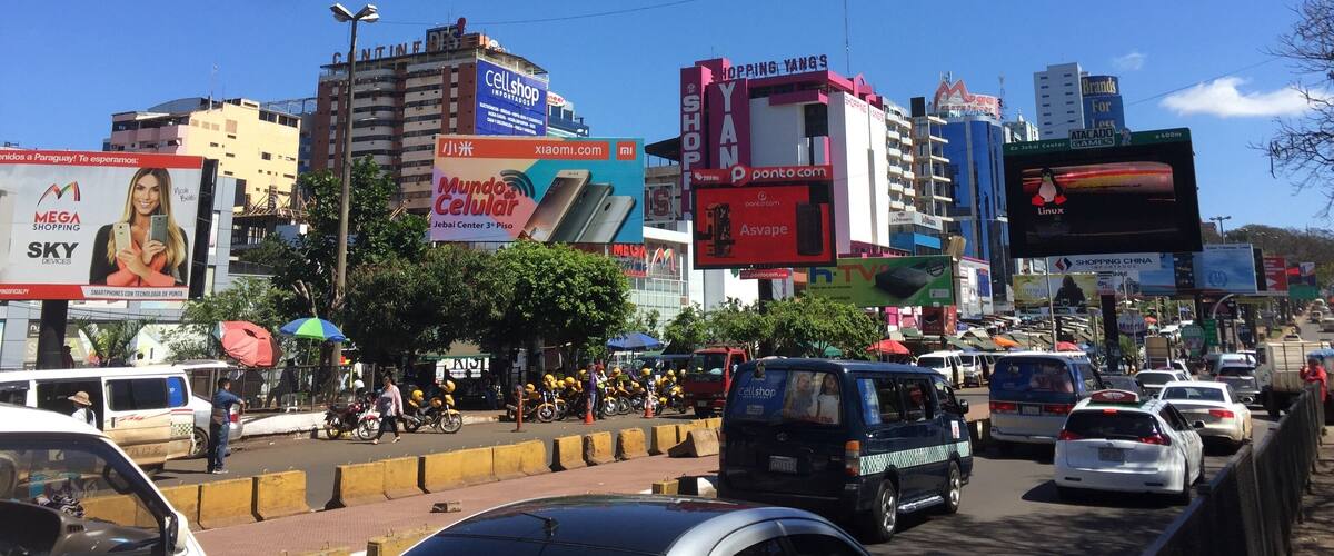 A busy urban street with various commercial billboards and advertisements.