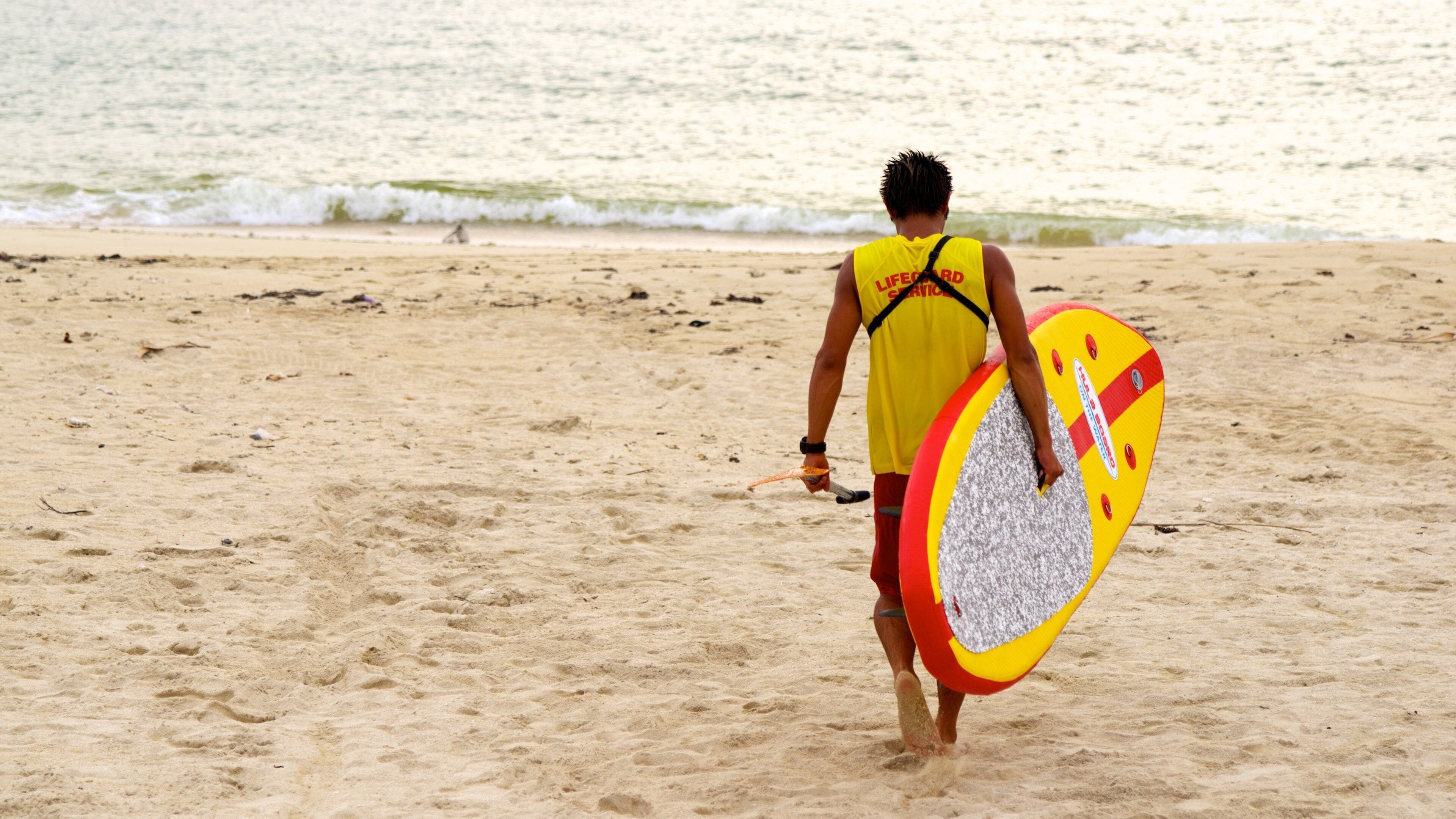 Okinawa ofreciendo una playa de arena y también un hombre