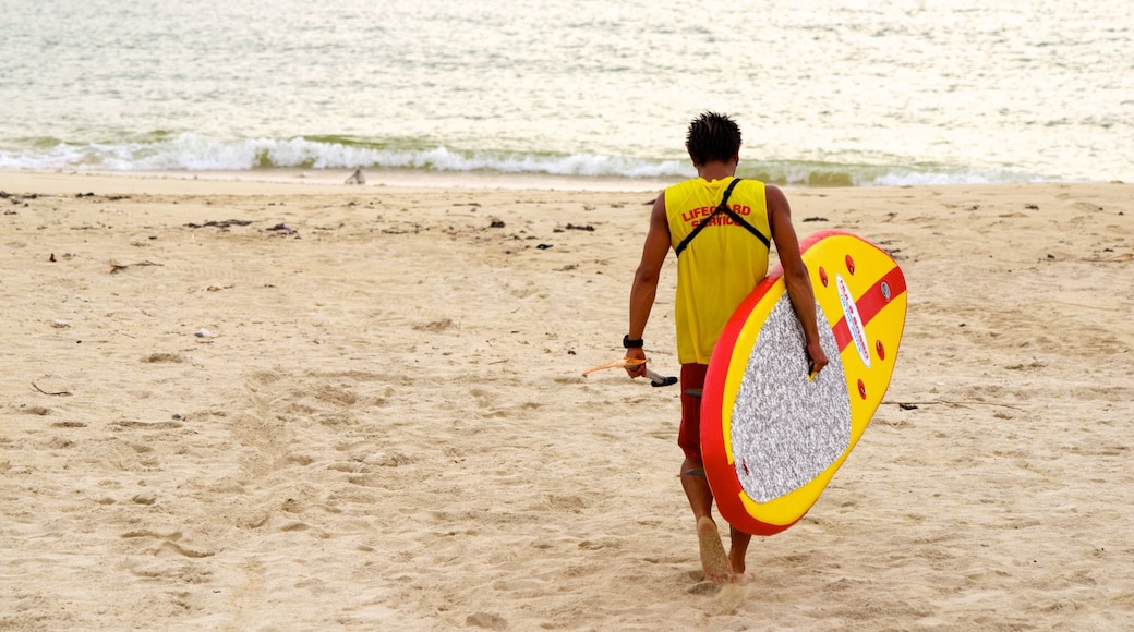 Okinawa ofreciendo una playa de arena y también un hombre
