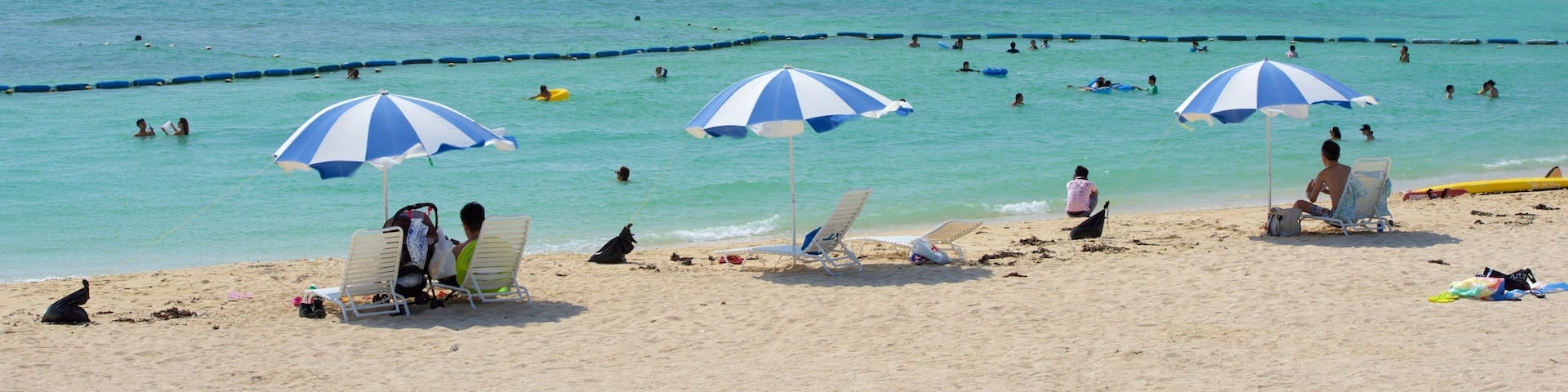 Okinawa which includes a sandy beach and swimming as well as a large group of people