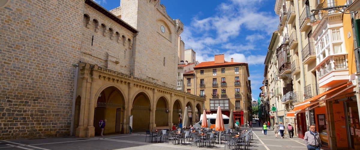 Iglesia de San Nicolas showing street scenes and a city as well as a small group of people