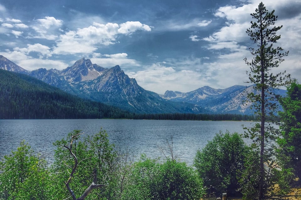A lake surrounded by mountains and dense forest.