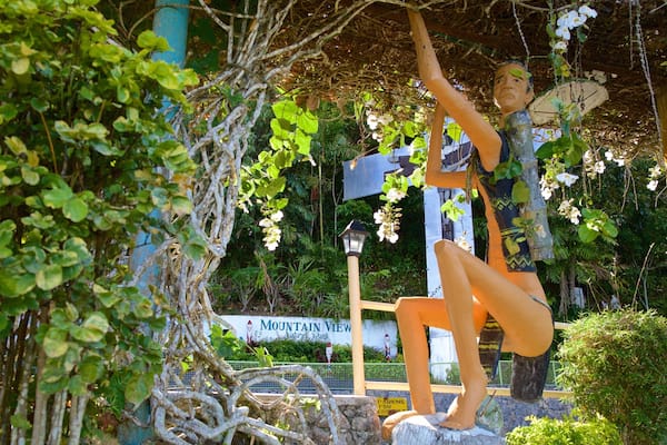 A sculpture of a person in a garden with a sign that reads "Mountain View Nature Park".