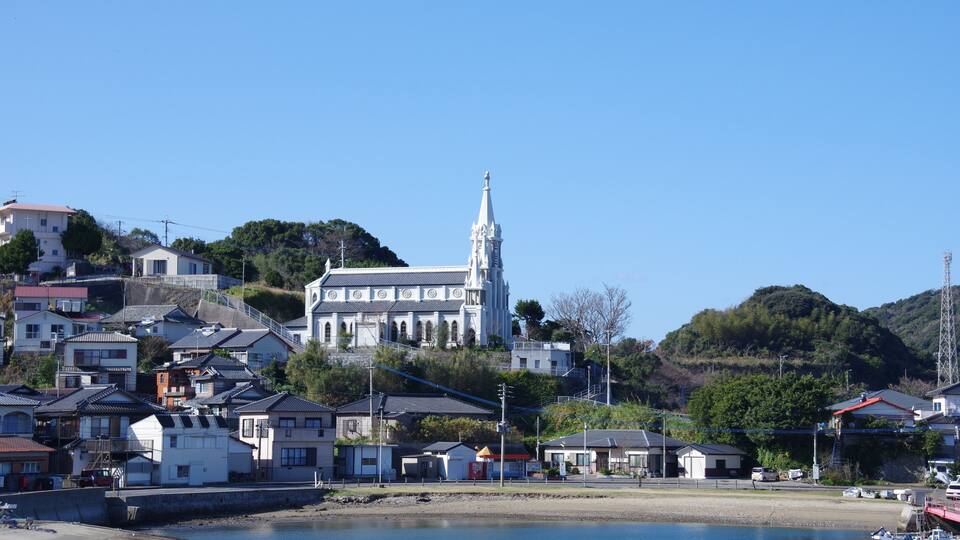 A coastal town with a prominent church, residential buildings, and a marina.