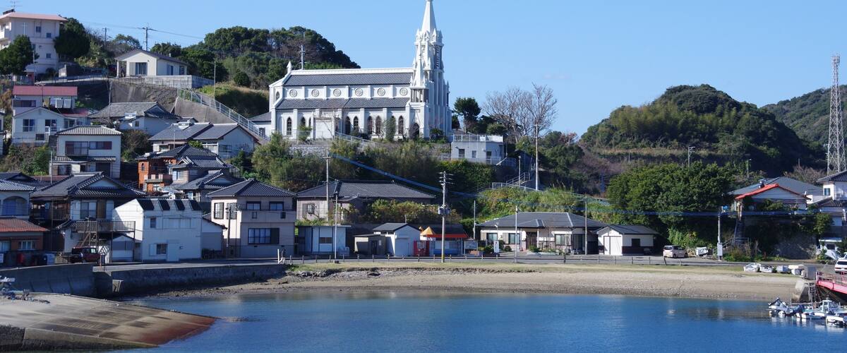 A coastal town with a prominent church, residential buildings, and a marina.