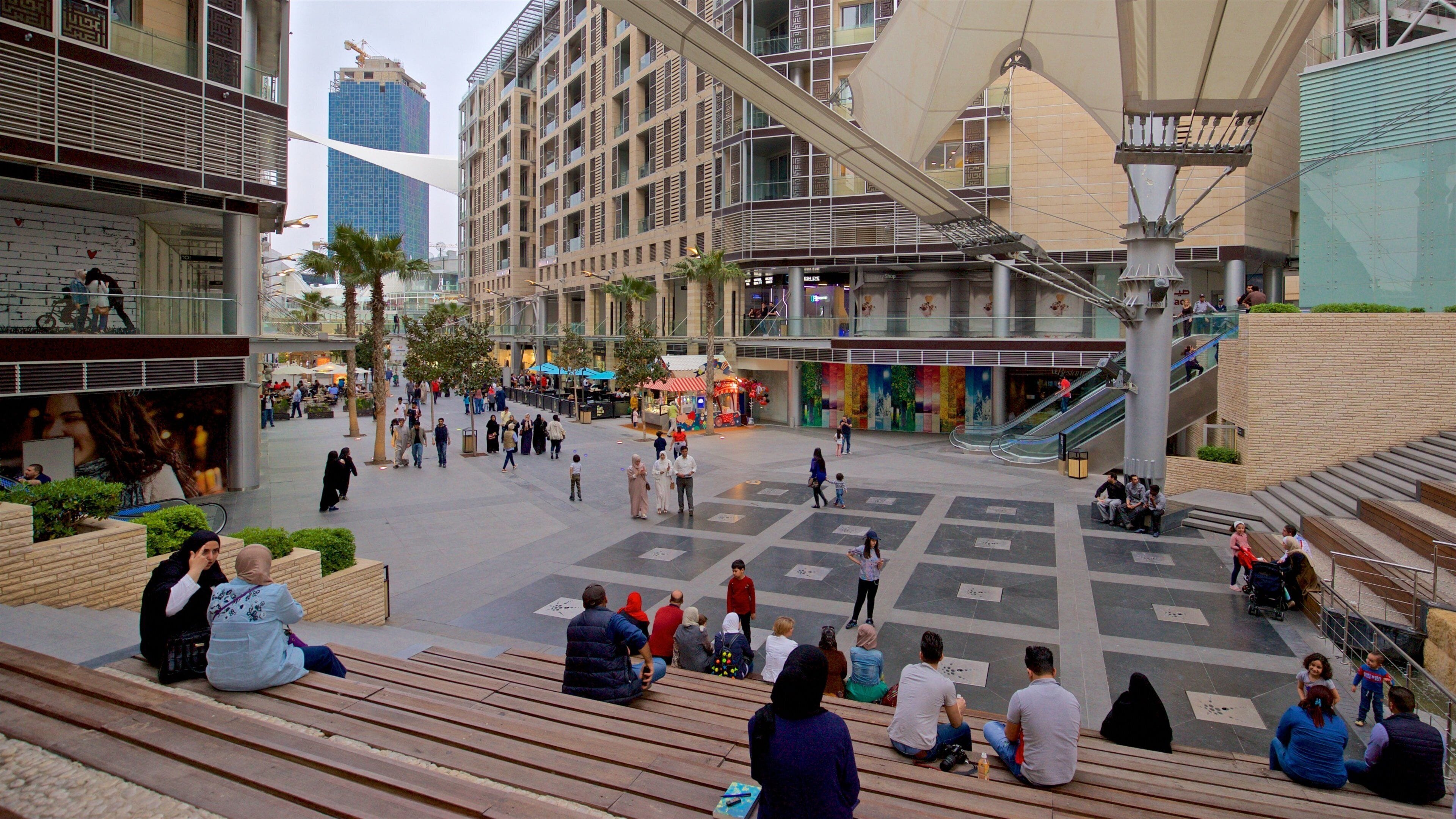 Al Abdali Mall which includes a square or plaza as well as a small group of people