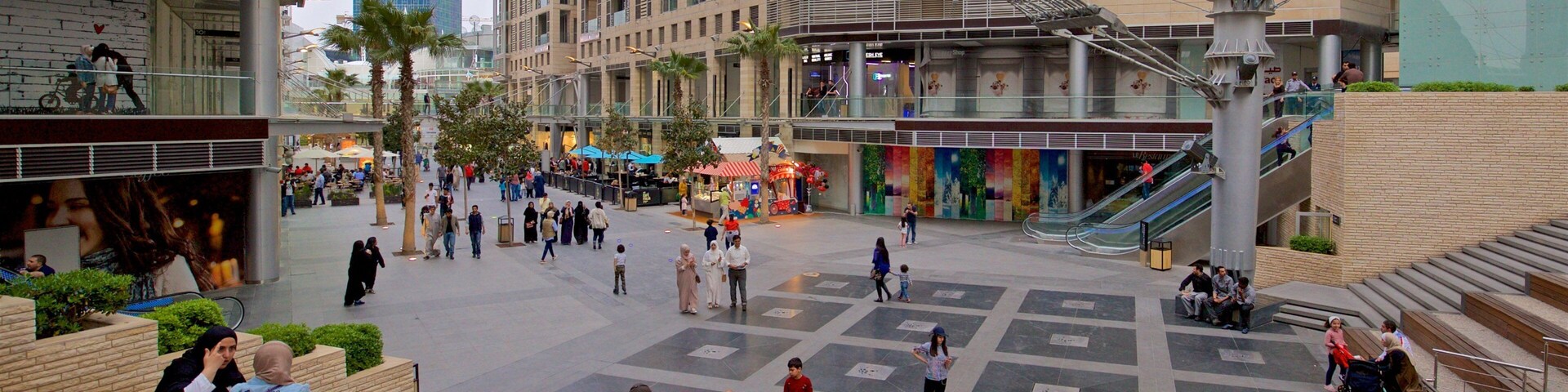 Al Abdali Mall which includes a square or plaza as well as a small group of people