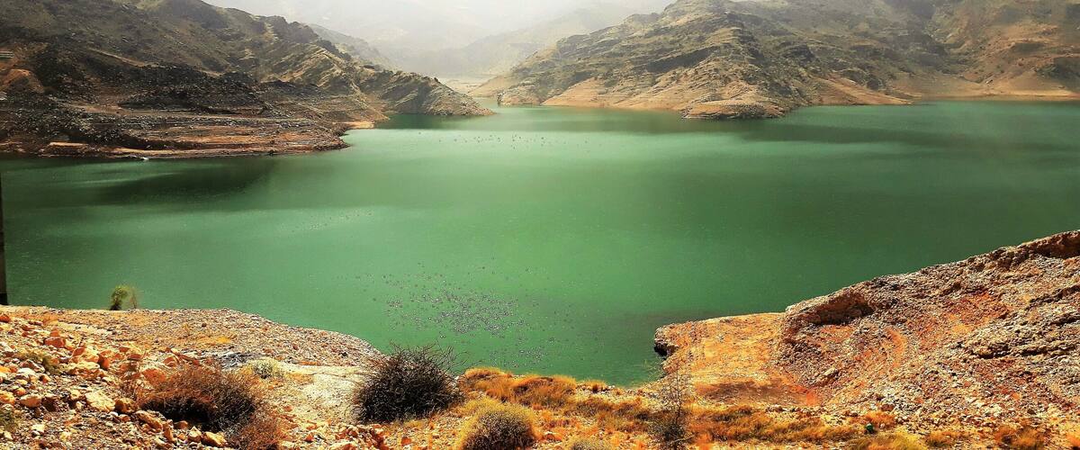 A green lake surrounded by rocky mountains.