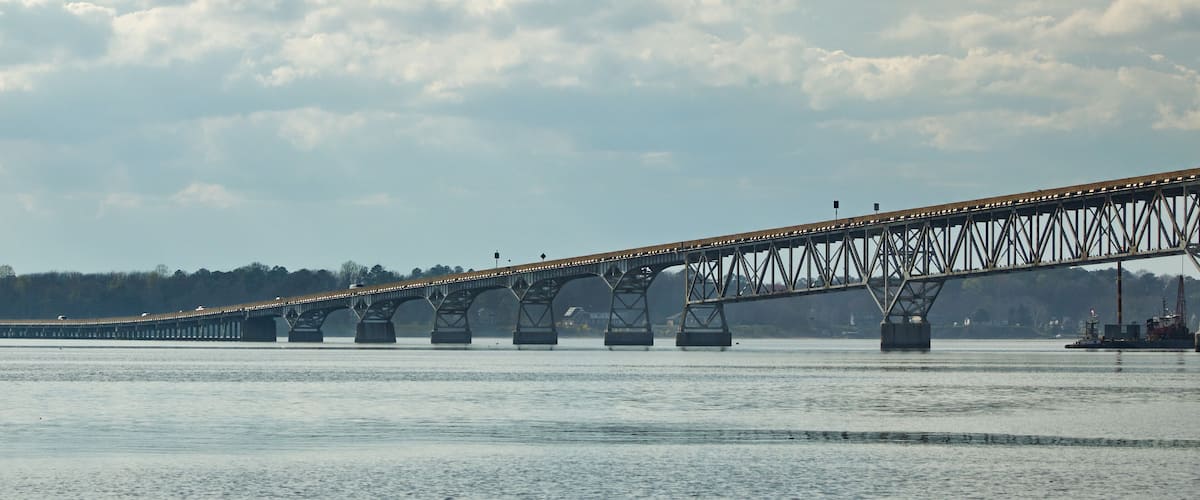 A large steel bridge spanning a wide river with multiple support pillars.