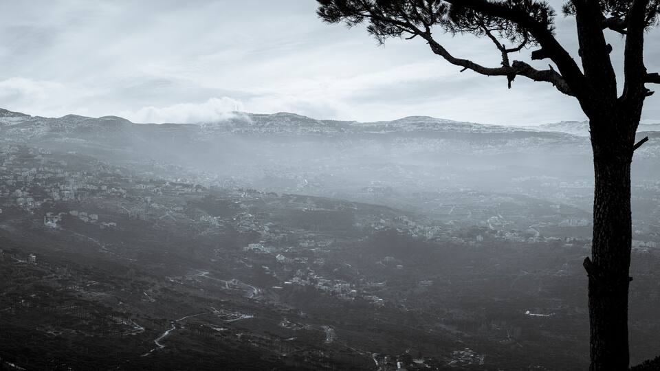 A snow-covered mountain range with a town in the valley below.